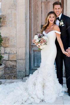 a bride and groom holding hands in front of an old wooden door with flowers on it