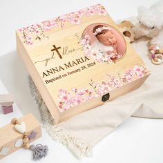 a wooden box with a baby's photo on it and two teddy bears next to it