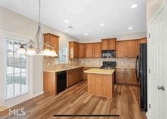 an empty kitchen with wood floors and cabinets in the middle of the room is shown