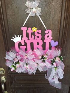 a door hanger that says it's a girl with flowers and a crown