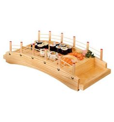 a wooden table with sushi and chopsticks on it in the shape of a boat