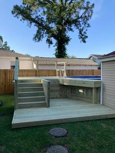 a wooden deck with steps leading up to an above ground hot tub in the back yard