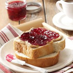 a peanut butter and jelly sandwich on a plate with jam in the bowl next to it