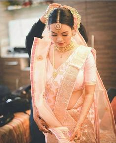 a woman in a white sari is getting ready to go on her wedding day