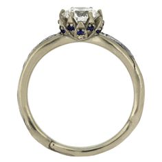 an antique style engagement ring with blue sapphire stones on the sides and two diamonds in the center