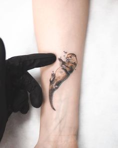 a small tattoo on the ankle of a woman's foot, with an image of a sea animal