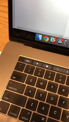 an open laptop computer sitting on top of a wooden table