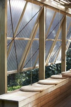 the inside of a wooden greenhouse with glass walls