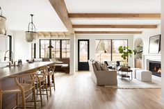 a living room filled with furniture and a fire place in the middle of a kitchen