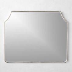 a mirror that is on the wall with a white frame and silver trim around it