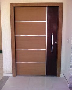 the door is made of wood and has glass panels on it, along with a white tiled floor