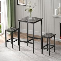 a small table with two stools next to a fire place in a living room