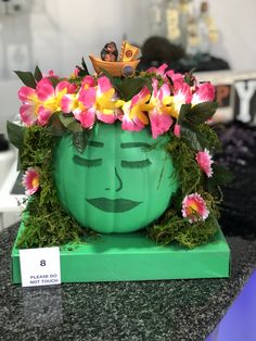 a green planter with flowers in the shape of a face