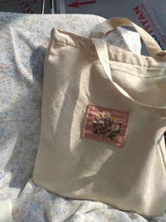 a white tote bag sitting on top of a bed