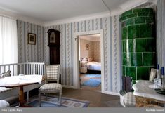 a living room filled with furniture and walls covered in striped wallpaper next to a doorway