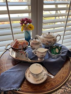 a table with some tea cups and plates on it