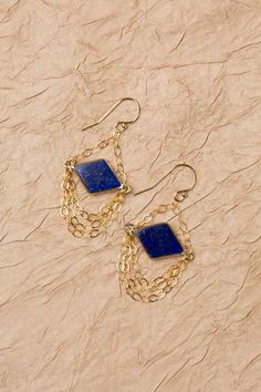 Discover the vibrant and stunning colors of the Blue Moon Collection in these eclectic earrings! Gold Filled (Lead & Nickel Free) Lapis Lazuli 1.75" with gold filled ear wires We hand select our natural materials, thus there may be slight variations in color and/or size that will not detract from the overall aesthetic. Our unique handcrafted designer jewelry for women is made in America, each design created individually in our personal design studio in Floyd, VA USA Eclectic Earrings, Floyd Va, The Blue Moon, Silver Gold Earrings, Silver Gold Necklace, Pyrite Necklace, Moon Collection, Cluster Earrings, Gold Collection