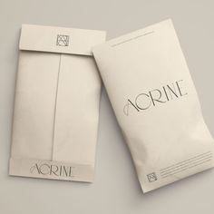 two envelopes sitting next to each other on top of a white surface with the word acrine printed on them