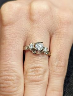 a woman's hand with a three stone ring on top of her left hand