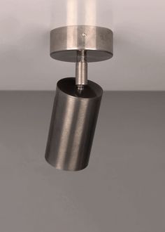 a light that is hanging from the ceiling in a room with gray walls and flooring