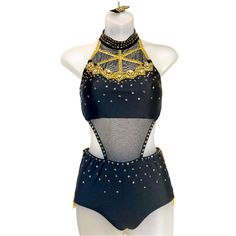 a female mannequin wearing a black and gold swimsuit with sequins