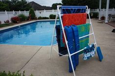 a pool with a ladder next to it and towels hanging on the rack by the pool