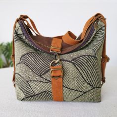 "This practical tapestry bag is easily convertible backpack.  Padded in cotton, and accompanied by soft and velvety artificial suede brown color, it is a bag suitable for both a day's work, and to convert it into a backpack that accompanies you day to day. It is a large capacity backpack bag, you can comfortably carry your 10\" tablet or your 13\" laptop. A very safe travel bag, with double outer closure, zipper and carabiner. It's a soft, flexible and sturdy bag; perfect for traveling with ever Brown Canvas Hobo Bag For Travel, Bohemian Hobo Bag With Detachable Strap For Travel, Brown Leather Trim Backpack Shoulder Bag, Brown Leather Trim Hobo Bag For Travel, Bohemian Canvas Hobo Bag For Travel, Tapestry Shoulder Bag With Removable Pouch For Travel, Versatile Brown Canvas Bag With Adjustable Strap, Versatile Brown Bucket Backpack Bag, Tapestry Satchel Shoulder Bag For Travel