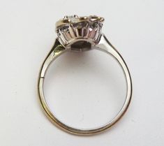 "This is a long diamond dinner ring from the 1960's. It would make a great right hand ring :) The ring is 14 karat white gold and is a long free form shape. It has a diamond set in the center and also at the bottom of the ring there are 4 smaller round diamonds. The top of the ring has a carved design which gives the illusion of more diamonds. The 5 stones have a combined total weight of 0.11 carats. The larger stone is I1 clarity and H color. The 4 smaller stones have SI-VS clarity and H color. Vintage Pear-shaped Diamond Ring With Brilliant Cut, Vintage Pear-shaped Brilliant Cut Diamond Ring, Formal Pear-shaped Diamond Ring With Rose Cut Diamonds, Heirloom Pear-shaped Diamond Ring For Formal Occasions, Vintage White Gold Pear-shaped Diamond Ring, Silver Pear-shaped Diamond Ring With Single Cut Diamonds, Vintage Pear-shaped Diamond Ring With Prong Setting, Silver Pear-shaped Diamond Ring With Single Cut, Vintage Pear-shaped Diamond Cut Ring