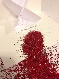 a card with red confetti on it next to a white envelope that says, you're more my joy