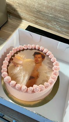 a cake in a box with an image of a woman on the frosting and pink icing