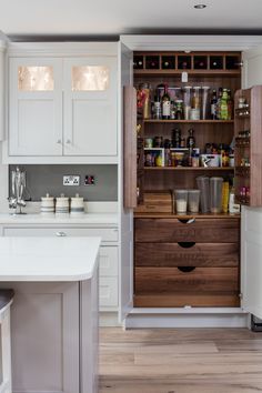 a kitchen with white cabinets and wooden drawers