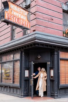 a man and woman standing in the doorway of a restaurant