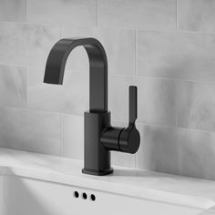 a black faucet sitting on top of a white sink next to a tiled wall