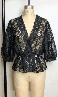 "DETAILS * romantic black lace blouse * puffed half sleeves * rhinestone buttons * elastic waist * completely sheer * perfect for a boudoir photoshoot ERA: 1980s LABEL: n/a SIZE: Medium shoulders: 15\" bust: 36\" (doubled) waist: 26\" sleeve length: 16\" length: 24\" FABRIC: feels like nylon COLOR: black CONDITION: excellent, has been dry cleaned! Please contact us about any questions you may have regarding condition before purchasing. We strive to mention and photograph as many flaws to note ho Peach Blouse, Black Lace Blouse, White Trim, Vintage Rhinestone, Lace Blouse, High Waisted Denim, Bell Bottoms, Half Sleeves, Black Lace