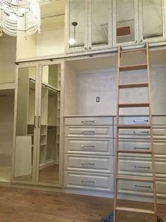 a ladder is in the middle of a room with drawers and closets on it