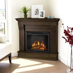 a living room with a fire place in the center and pictures on the wall above it