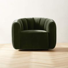 a green chair sitting on top of a hard wood floor next to a white wall