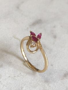 14kt Yellow Gold Lady's Diamond and Ruby Ring consisting of 3 Marquise genuine fine deep red Rubies and one .03ct total weight full cut round brilliant diamond accent. This unique shape mounting shows off all the gemstones and diamond. This finger size is 5. Ruby is the birthstone for July. This item would Retail for $479.00 Red Brilliant Cut Birthstone Ring Fine Jewelry, Fine Jewelry Red Birthstone Ring With Brilliant Cut, Red Birthstone Ring With Brilliant Cut In Fine Jewelry, 14k Gold Red Cluster Ring With Brilliant Cut, Red Marquise 14k Gold Jewelry, Fine Jewelry Ruby Birthstone Ring With Diamond Accents, Red 14k Gold Marquise Cut Jewelry, Red Marquise-cut 14k Gold Jewelry, Red Marquise Ring With Diamond Accents