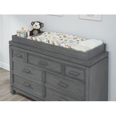 a baby crib with drawers and a teddy bear