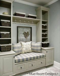 a room filled with lots of shelves and drawers next to a couch in front of a painting