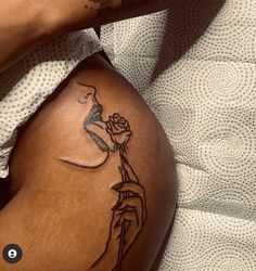 a woman's leg with a tattoo on it and a rose in her hand