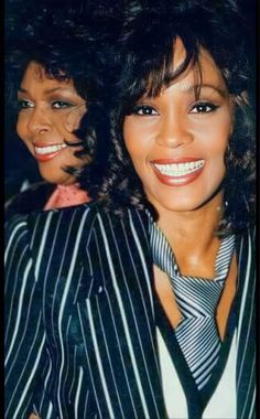 two women in striped shirts and ties posing for the camera with their arms around each other