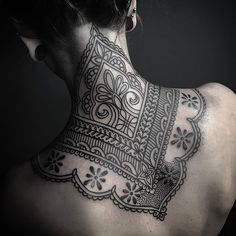 the back of a woman's neck with an intricate design on it