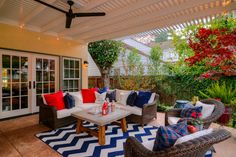 an outdoor living area with couches, tables and chairs