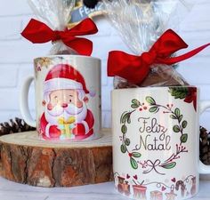 two coffee mugs decorated with santa claus and pine cones are sitting next to each other