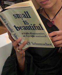 a woman reading a small is beautiful book