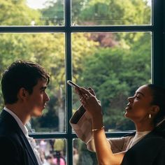 a man and woman are looking out the window