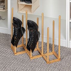 two pairs of black shoes are sitting on wooden shoe racks