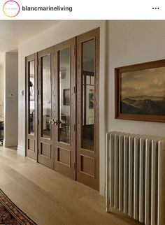 a living room filled with furniture and a radiator next to a painting on the wall