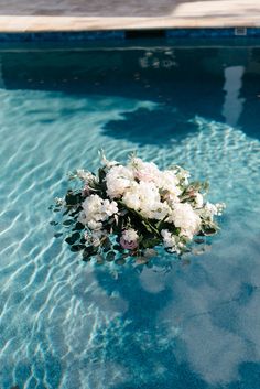 a bouquet of flowers floating in a swimming pool